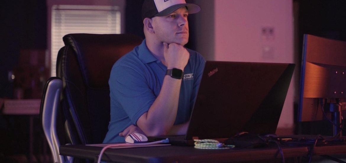 Preston at his desk reviewing a machine program